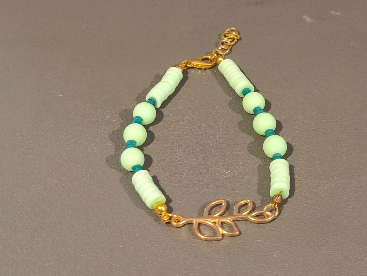 Bracelet vert avec branche de feuilles dorée